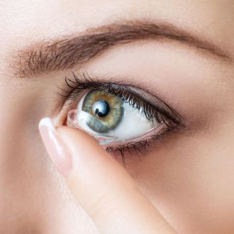 Pose d'une lentille sur un oeil vert d'une femme